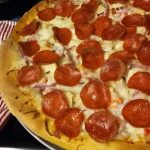 Pizza with cheese, onions, and pepperoni