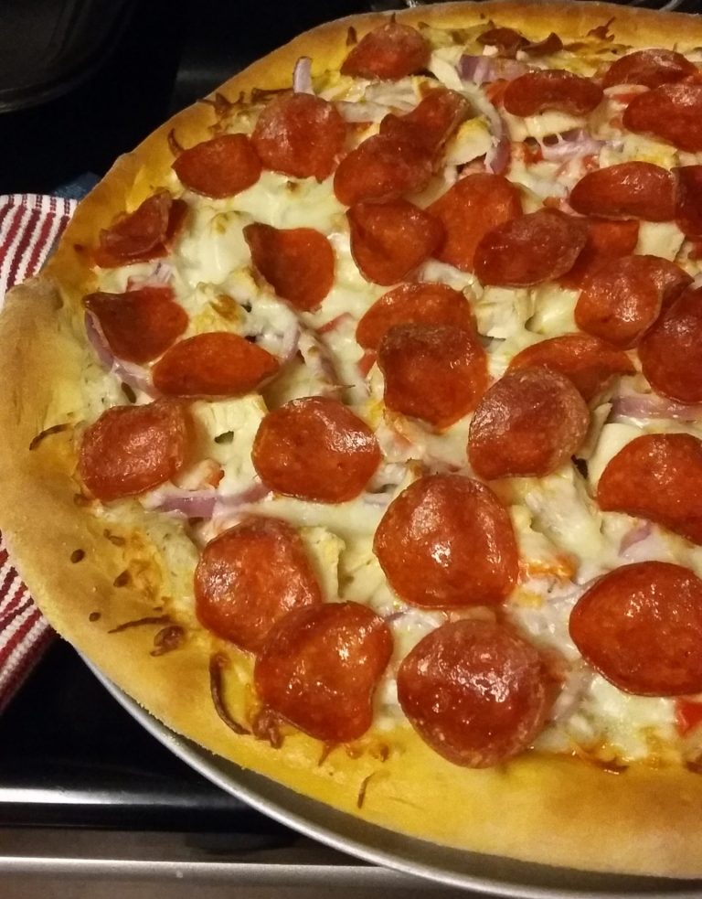 Pizza with cheese, onions, and pepperoni