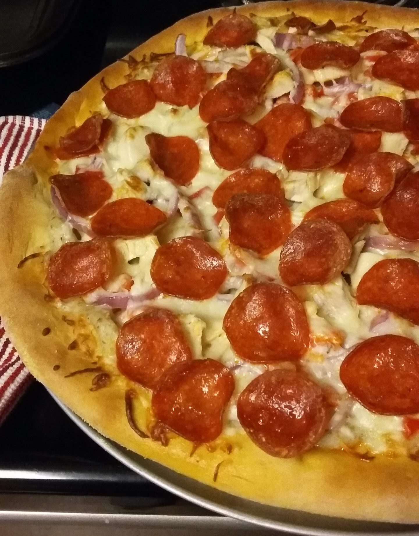 Pizza with cheese, onions, and pepperoni