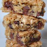 brown bars with chocolate chips stacked on top of each other