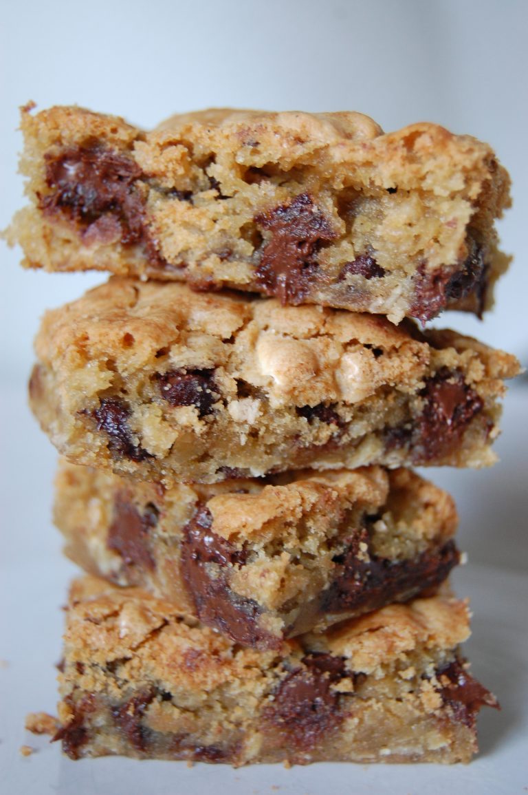 brown bars with chocolate chips stacked on top of each other