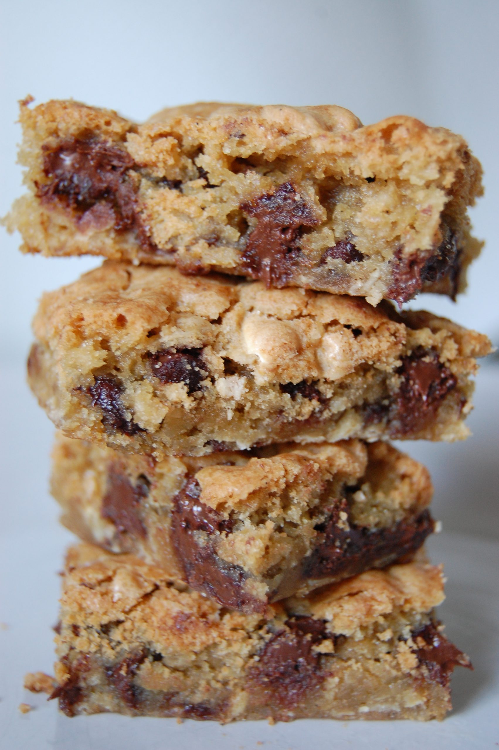 brown bars with chocolate chips stacked on top of each other