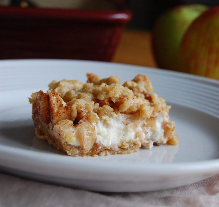 white plate with square dessert with apples and cream cheese