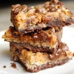 Brownie bars with chocolate chips stacked on top of one another on a white plate