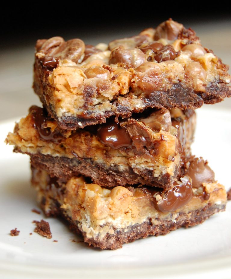 Brownie bars with chocolate chips stacked on top of one another on a white plate