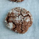 brown cookie with cracks and white powdered sugar on top