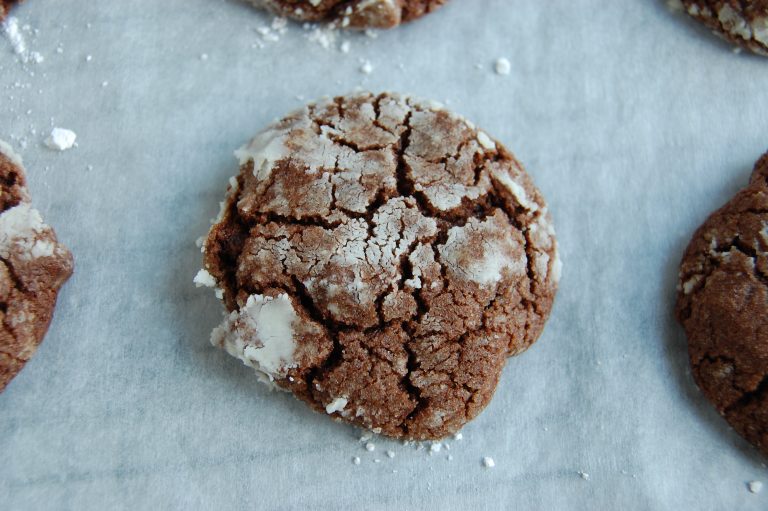 brown cookie with cracks and white powdered sugar on top