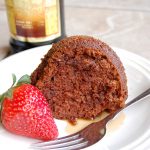 brown chocolate cake on white plate with fork, Kahlua in back
