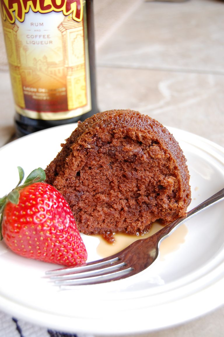 brown chocolate cake on white plate with fork, Kahlua in back