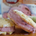 yellow cookies with pink ice cream sandwiched in the middle