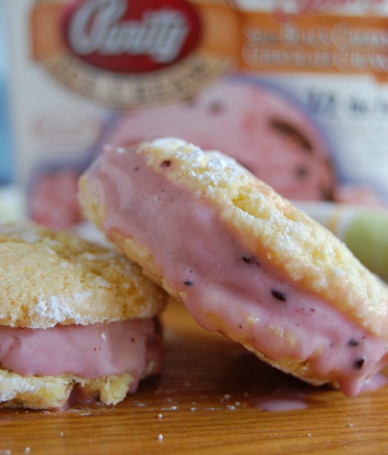 yellow cookies with pink ice cream sandwiched in the middle