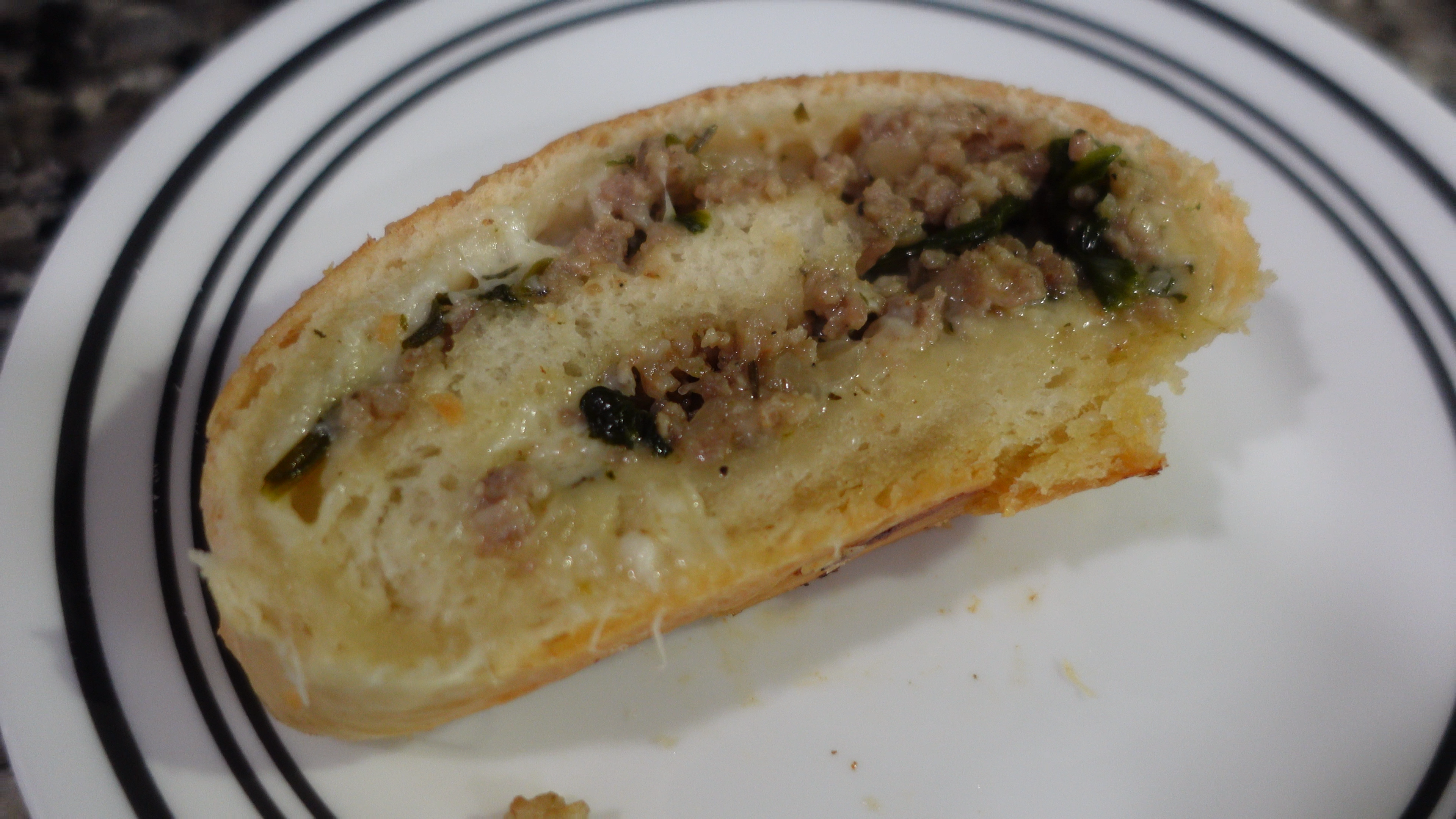 bread rolled with sausage, spinach, and cheese in the middle