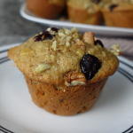 muffin topped with cranberries and pecans on a white plate